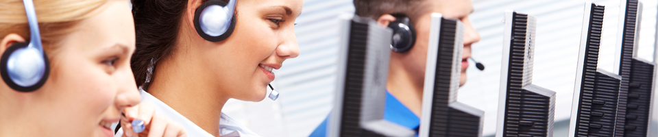 Team of customer support with phone headsets and monitors